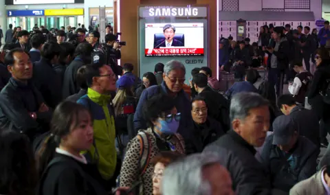 AFP/Getty South Koreans watch as the verdict is broadcast live