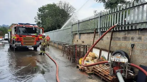 Charmouth Fire station Fire fighters pumping water