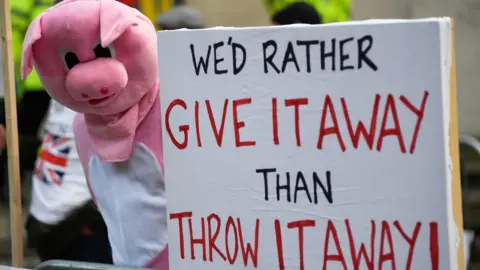 Reuters Pig farmers protested outside the Conservative Party conference in Manchester on Monday