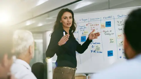 Getty Images Woman teaching using whiteboard
