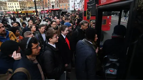 EPA People getting on packed bus at Victoria station