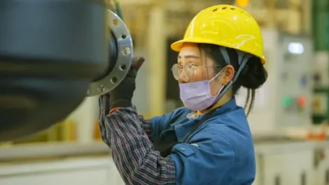 Getty Images A quality inspector makes the final inspection of a Daimler axle housing before packing it for export at the Daimler axle housing production plant in Qingdao, Shandong Province, China, January 20, 2022