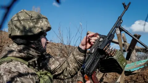 Reuters A Ukrainian serviceman holds a machine gun at a town in Donetsk