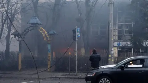 Reuters A person looks at a building after a blast, amid Russia's invasion of Ukraine, in Kyiv