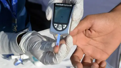 Getty Images A nurse collects a blood sample using a glucometer at a free diabetic health check-up camp