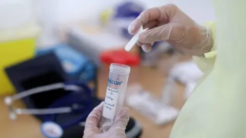 Reuters Someone working with a test tube