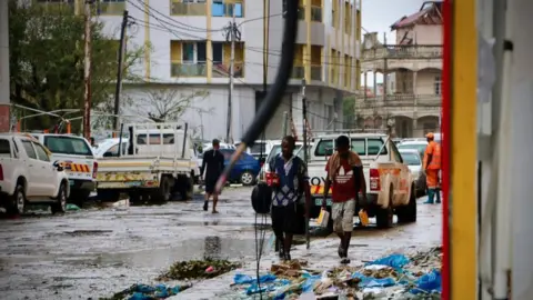 Getty Images People walk through the ravaged pavements of Beira, Mozambique