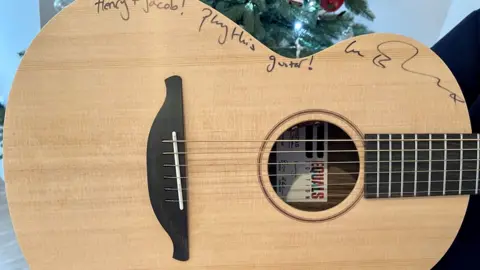 GeeWizz/PA Media The guitar has been personalised by Ed Sheeran