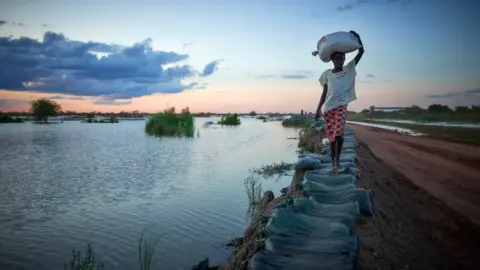 Christina Simons A woman walking along a dye in Bentiu, South Sudan