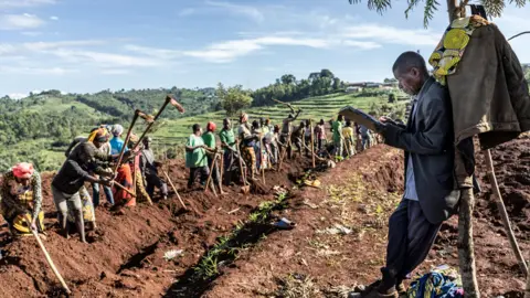 Clement Di Roma/AFP Residents of Mubirizi village digging in Rwanda - Friday 5 May 2023