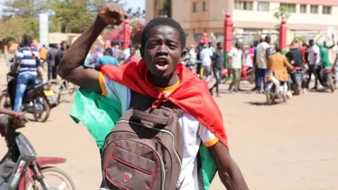 A teenager reacts as he shows support for the military after Burkina Faso President Roch Kaboré was detained at a military camp in Ouagadougou, Burkina Faso, on 24 January 2022