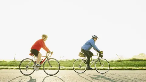 Getty Images Two cyclists riding along a road
