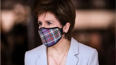 Getty Images First Minister of Scotland Nicola Sturgeon wears a Tartan face mask as she visits New Look at Ford Kinaird Retail Park on June 26, 2020