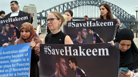 AFP Protesters hold #SaveHakeem signs in front of the Sydney Harbour Bridge