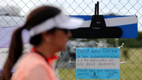 Reuters woman walking past a supportive sign on the fence