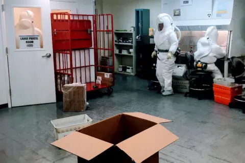 Getty Images Pentagon officials wear protective suits as they inspect the quarantined mailroom