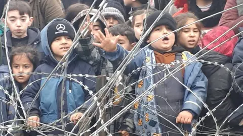 Polish interior ministry This Polish interior ministry screengrab shows children behind the razor-wire fence