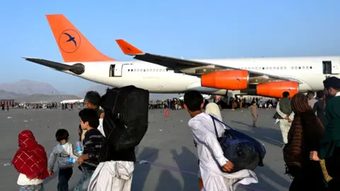 Getty Images Families flee at Kabul airport