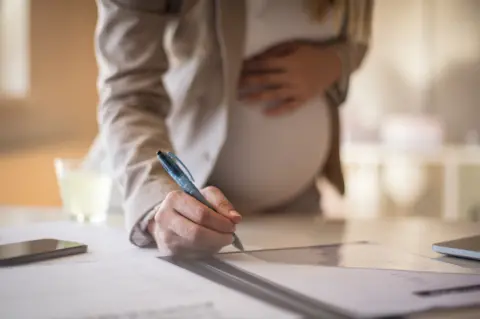 Getty Images A pregnant woman at work