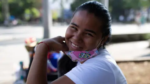 Danexi Andrade smiles while she is selling sweets in Medellin