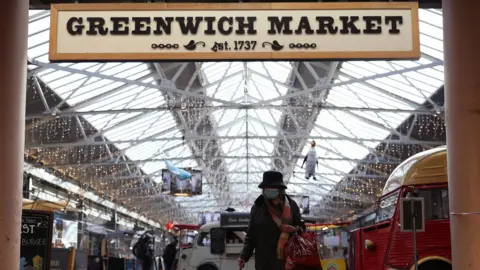 PA Media A woman wearing a face mask in Greenwich Market, London