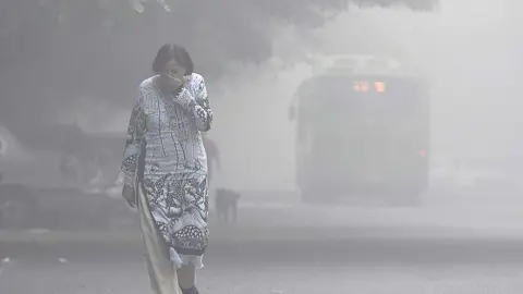 Getty Images A women covers her face with her hands as she walks amid heavy smog in the early morning at Mayur Vihar area, on November 2, 2016 in New Delhi, India.