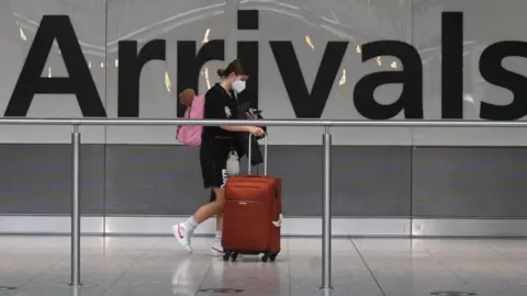 Getty Images Woman at Arrivals in Heathrow Airport.