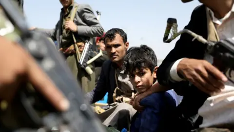 Reuters A boy rides with Houthi supporters in a vehicle during a funeral in Sanaa, Yemen (22 September 2020)