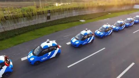 Getty Images A row of Baidu driverless cars being tested on a track.