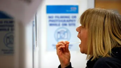 Getty Images A woman carries out a swab test in west London