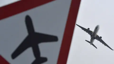 Reuters Images of a Qatar Airways plane and a sign warning of planes