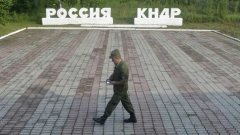 Reuters A guard walks along a platform past signs, which read "Russia" (L) and "DPRK"(Democratic People"s Republic of Korea), at the border crossing between Russia and North Korea in the settlement of Tumangan, North Korea July 18, 2014