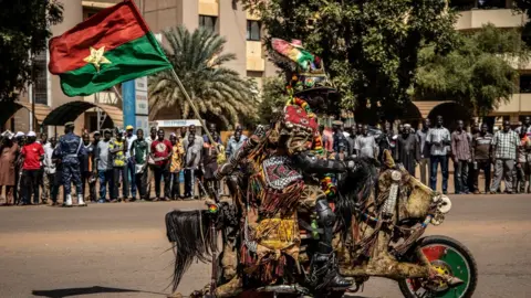 Getty Images A man rides a decorated motorbike on the sideline of the last stage of the 32nd edition of the Tour du Faso 2019 cycling race, in Ouagadougou, on November 3, 2019. (
