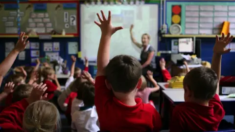 PA Media pupils with hands raised in a classroom