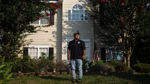 Dustin Duong for the BBC Zia Ghafoori stands in front of his home in North Carolina