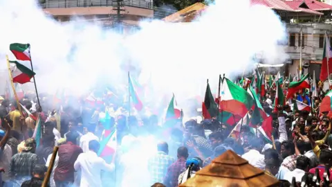 Getty Images Police use tear gas to disperse members and activists of the Popular Front of India (PFI) during a demonstration to protest against what they say is police targeting its leaders