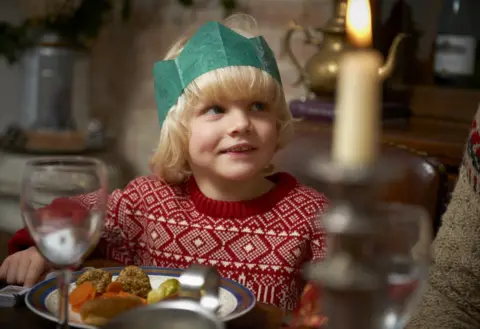 Mike Harrington/GEtty Images Child sitting at table for Christmas lunch