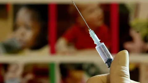 Gareth Fuller View of hand holding a vaccine