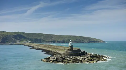 Getty Images Fishguard Harbour wall and lighthouse with sea defences, Pembrokeshire