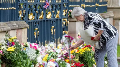 PAUL FAITH/GETTY IMAGES Mourners are continuing to lay flowers outside Hillsborough Castle