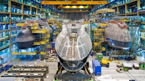 BAe Systems The forward end construction of the fifth Astute class submarine, Anson, lining up alongside her sisters, Artful and Audacious