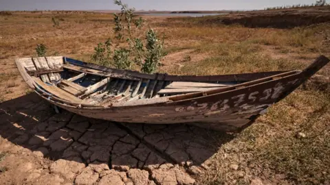 AFP A boat sits over cracked earth at al-Massira dam in Ouled Essi Masseoud village
