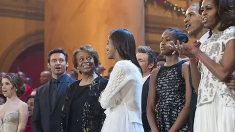 SAUL LOEB/AFP via Getty Images The Obama's on stage singing during a taping of TNT's Christmas in Washington