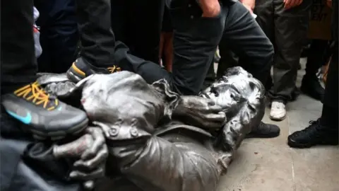 Reuters Crowds stamped on the statue after it was removed