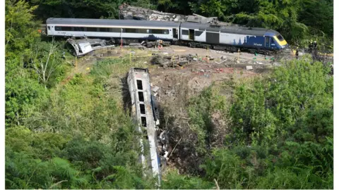 PA Media Emergency services inspect the scene near Stonehaven, Aberdeenshire, following the derailment of the ScotRail train which cost the lives of three people.