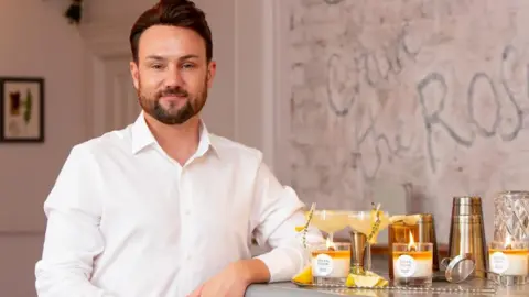 Drew Cockton Drew Cockton with a range of candles from his business