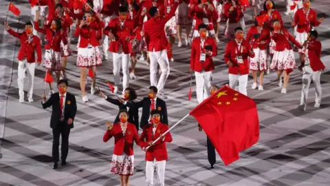 Getty Images Flag bearers Ting Zhu and Shuai Zhao of Team China lead their team out during the Opening Ceremony of the Tokyo 2020 Olympic Games at Olympic Stadium on July 23, 2021 in Tokyo, Japan.