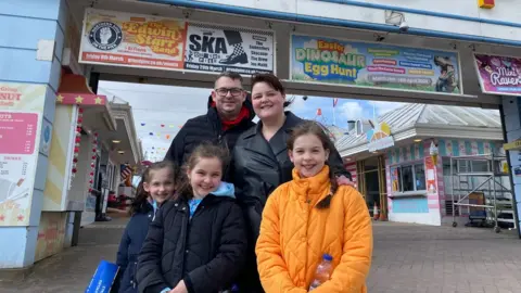 A family on holiday at Weston super Mare standing on the Grand Pier