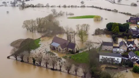 PA Media Flood water continues to surround Severn Stoke in Worcestershire, in the aftermath of Storm Dennis