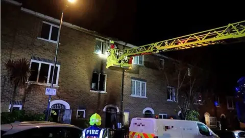 London Fire Brigade Firefighters accessing the house involved in the fire from the top floor